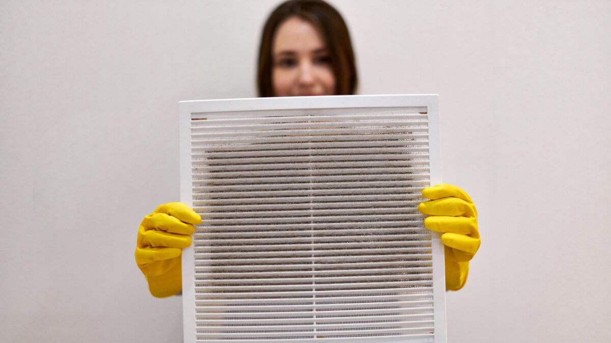 Woman holding up dirty air filter