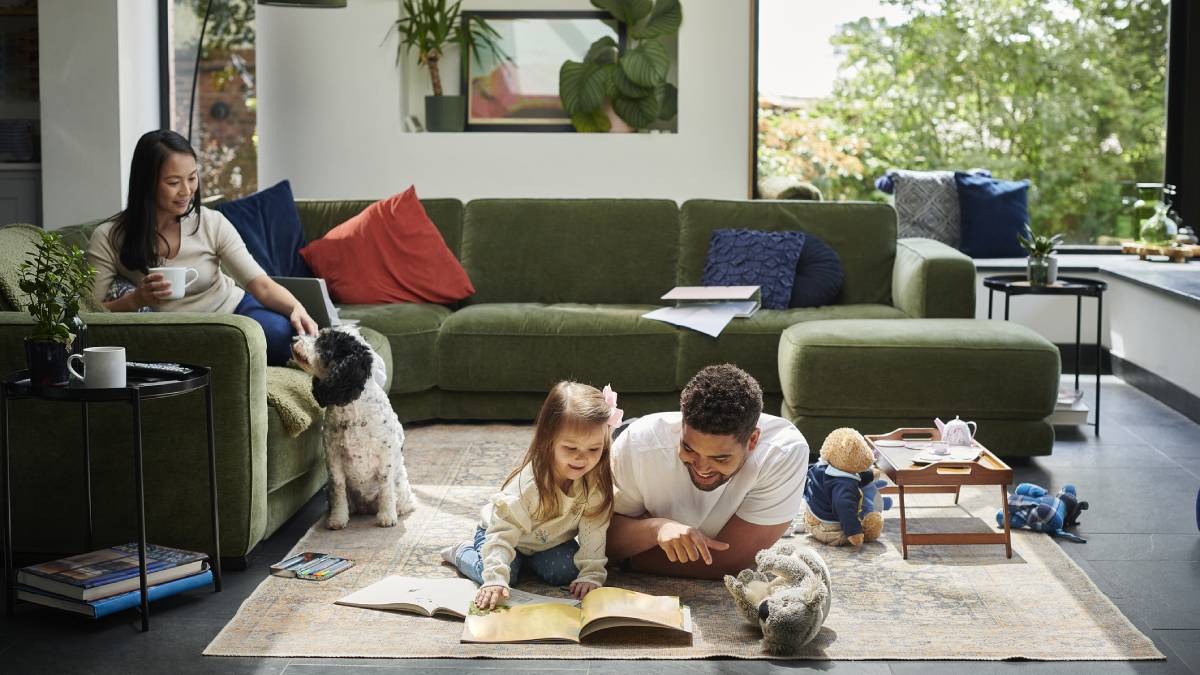 Father and daughter reading on living room floor